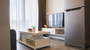 A modern kitchen with a built-in refrigerator, a flat-screen TV, and a dining area with a table and chairs. - Cambodian Country Club (Phnom Penh)