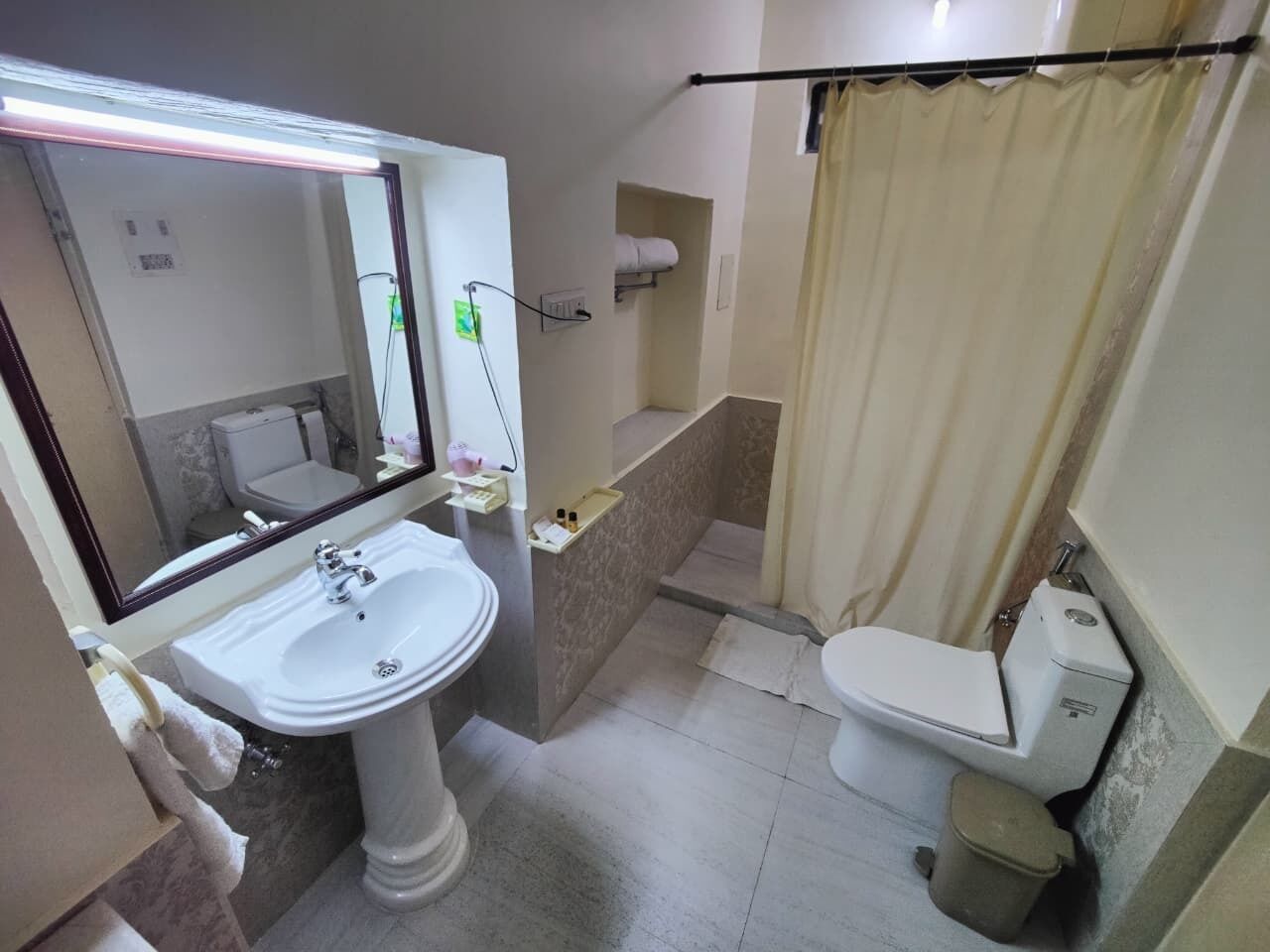 A bathroom with a sink, toilet, and shower curtain.