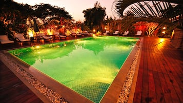 Een buitenzwembad en ligstoelen