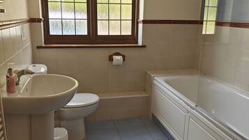 A bathroom with a toilet, sink, and bathtub.