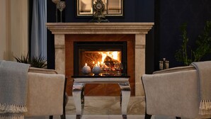 A cozy living room with a fireplace, two armchairs, and a coffee table. - Villa Hoff Wellness & SPA Hotel (Rewal)