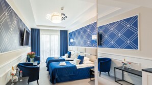 A hotel room with two beds, a TV, a desk, and a mirror. - Villa Hoff Wellness & SPA Hotel (Rewal)