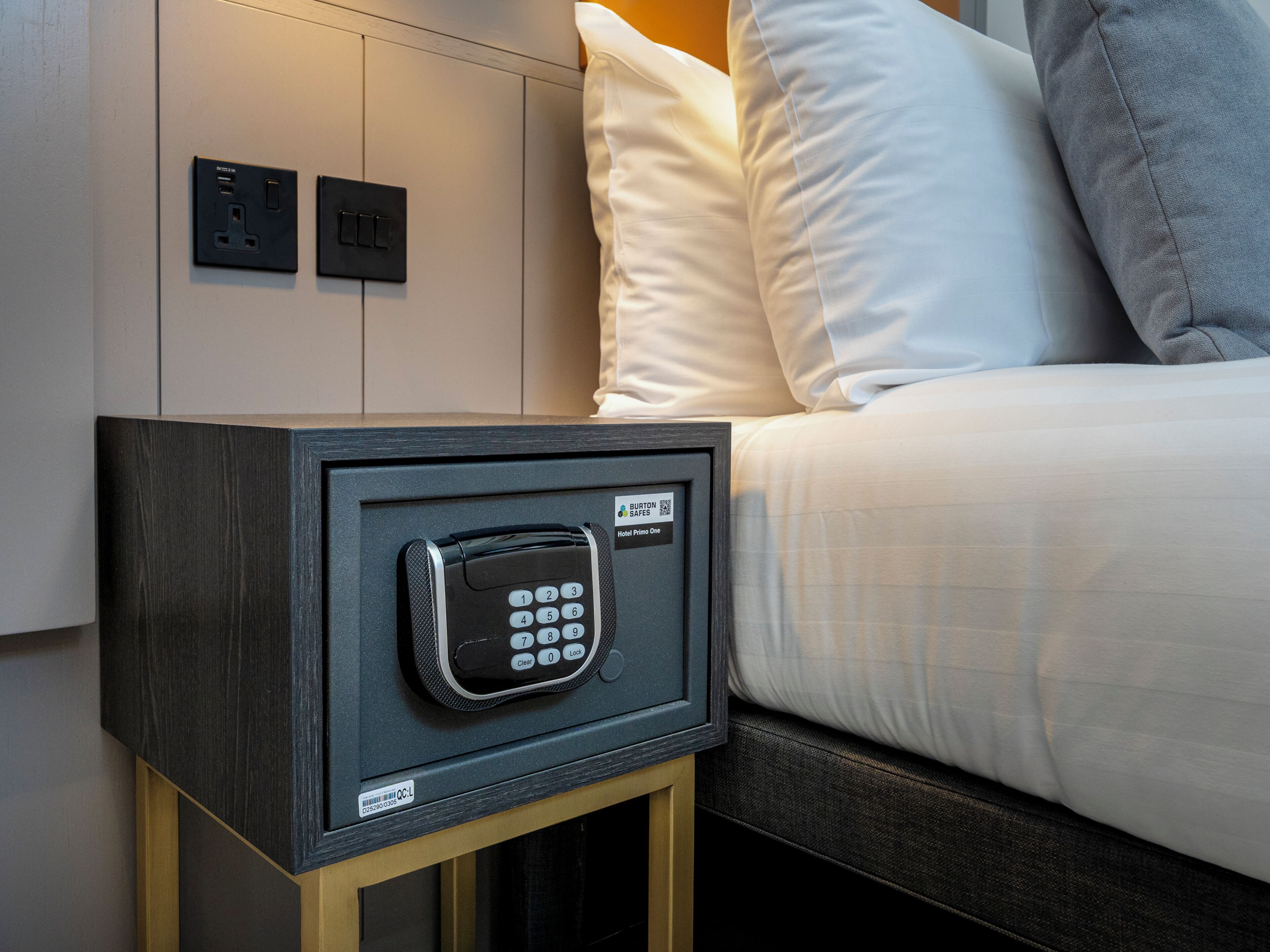 A secure safe with a keypad lock, a power outlet, and a label indicating 'Hotel Primo One.'