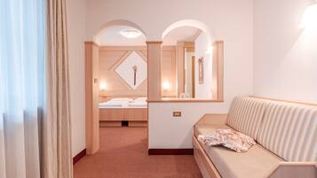 Une chambre d’hôtel avec un lit, un canapé, un miroir et une petite table.