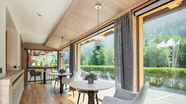 Un intérieur moderne avec des planchers en bois, des tables rondes et des chaises grises.