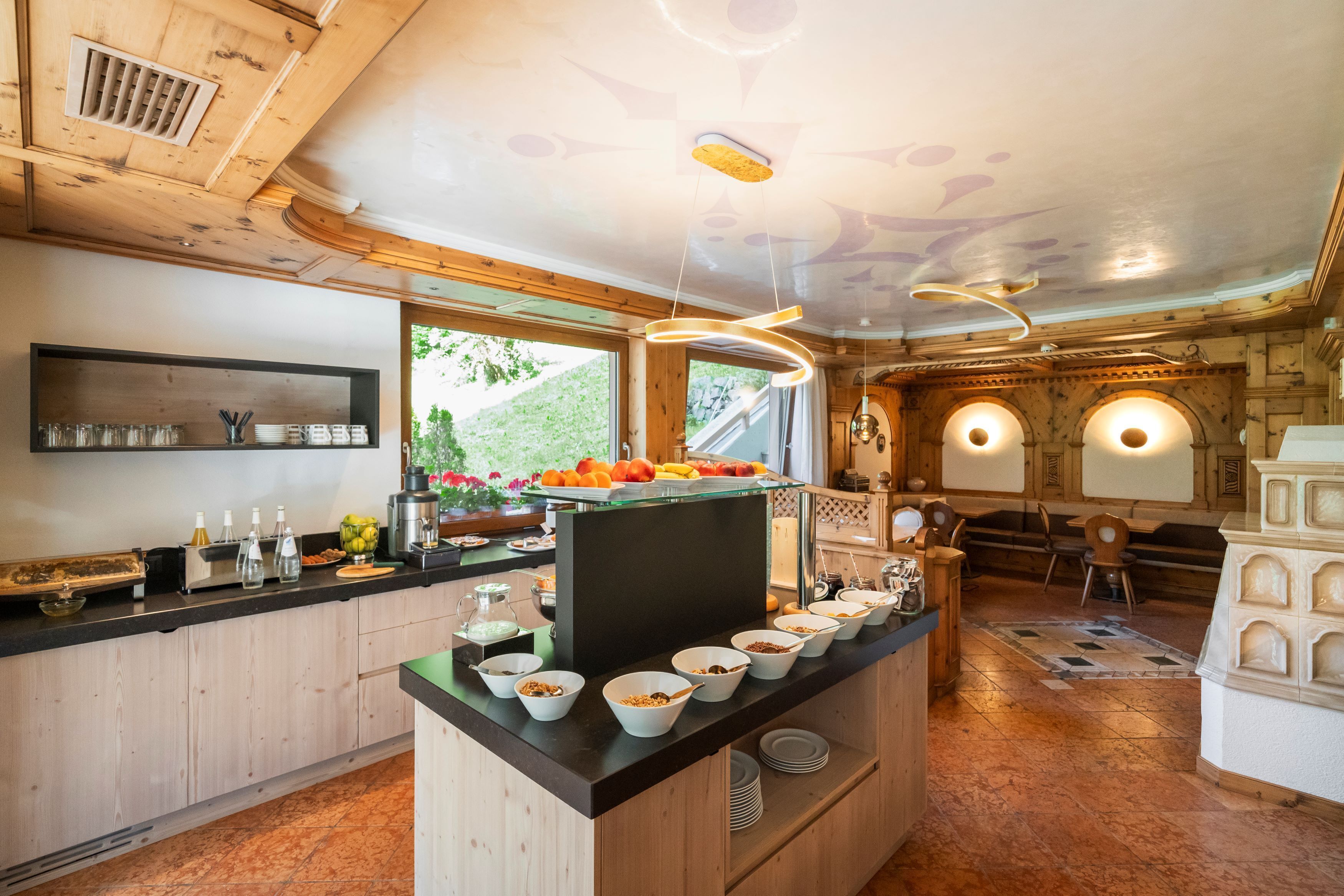 A breakfast bar with bowls of cereal, a coffee machine, and a fruit display.