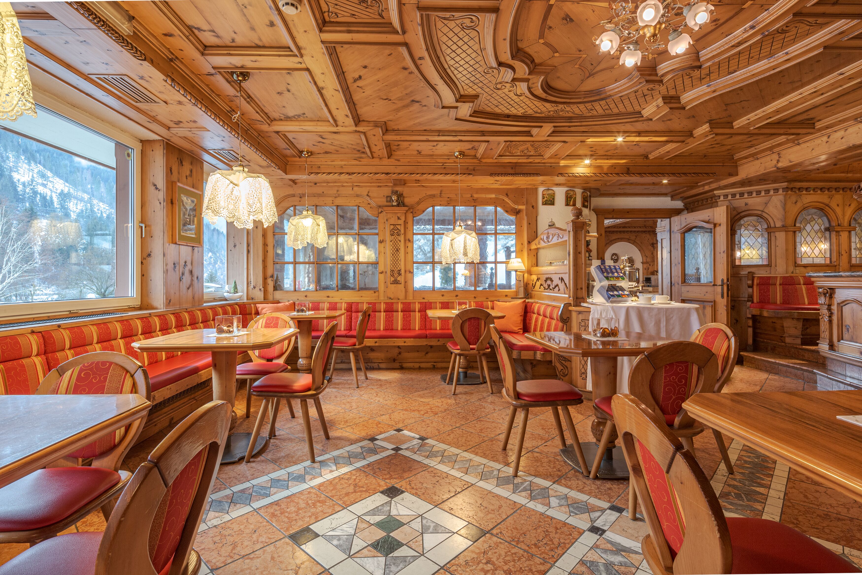 Un restaurant avec un décor intérieur en bois, des banquettes rouges rembourrées et un sol carrelé.