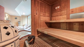 Et sauna rum med trævægge, en træbænk og en stor keramisk ovn.