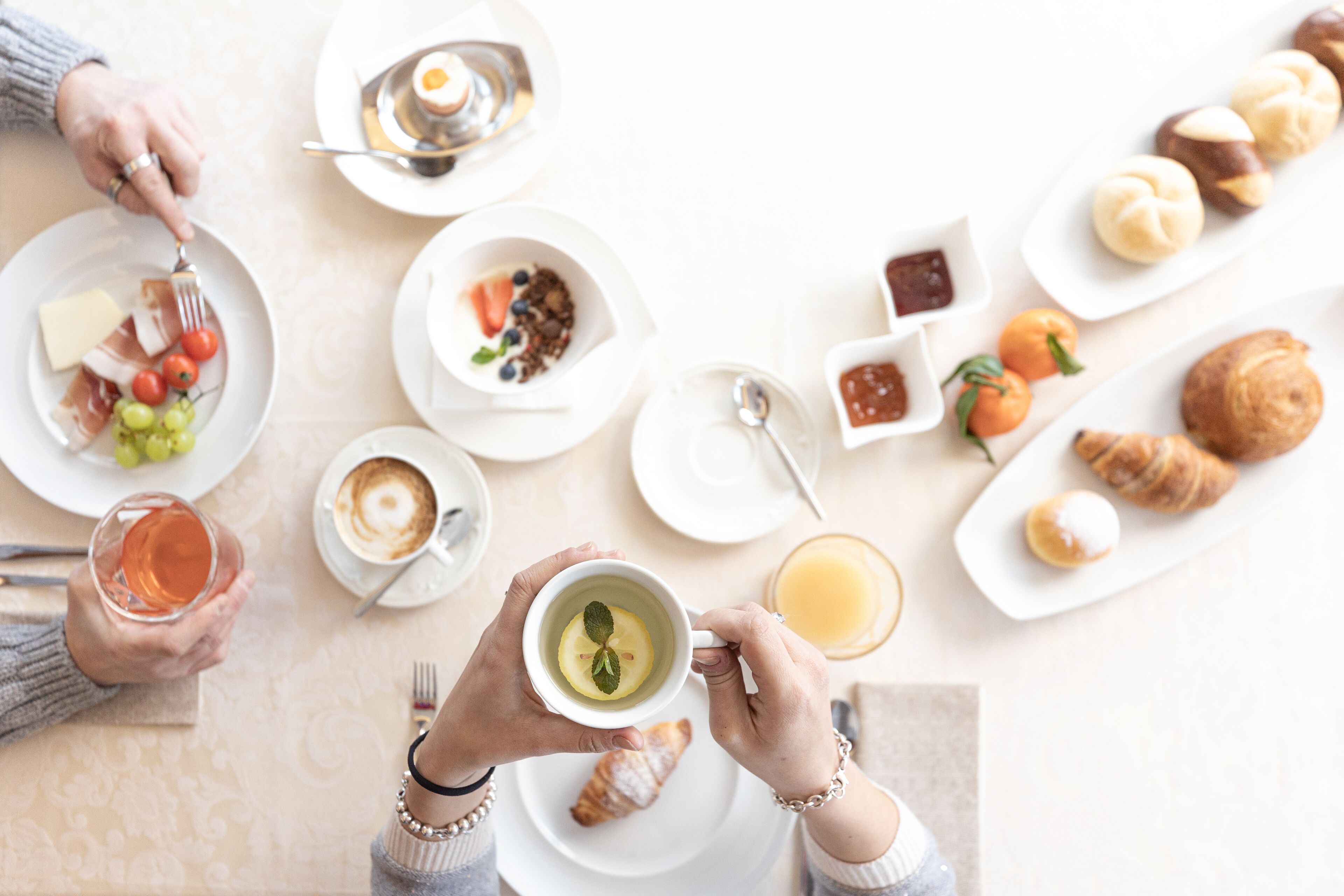 Una escena de desayuno con diferentes alimentos y bebidas sobre platos.