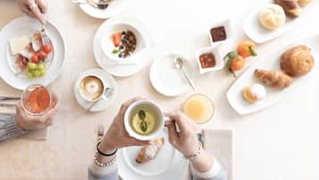Una escena de desayuno con diferentes alimentos y bebidas sobre platos.