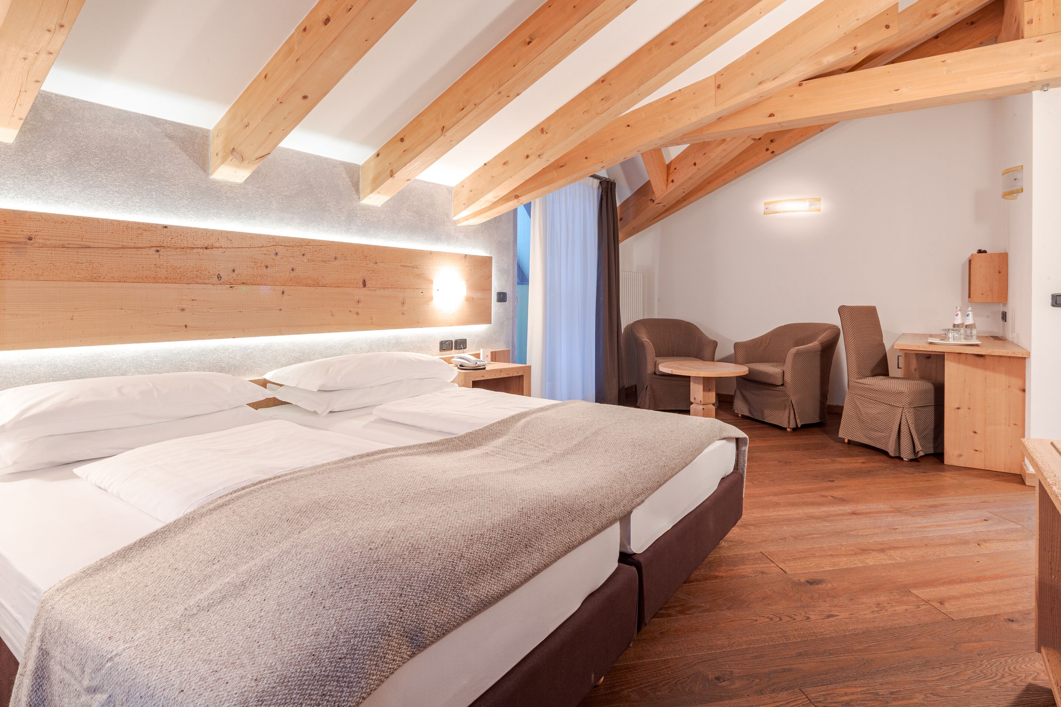 Ein modernes Hotelzimmer mit einem großen Bett, einem Schreibtisch und einem Stuhl.