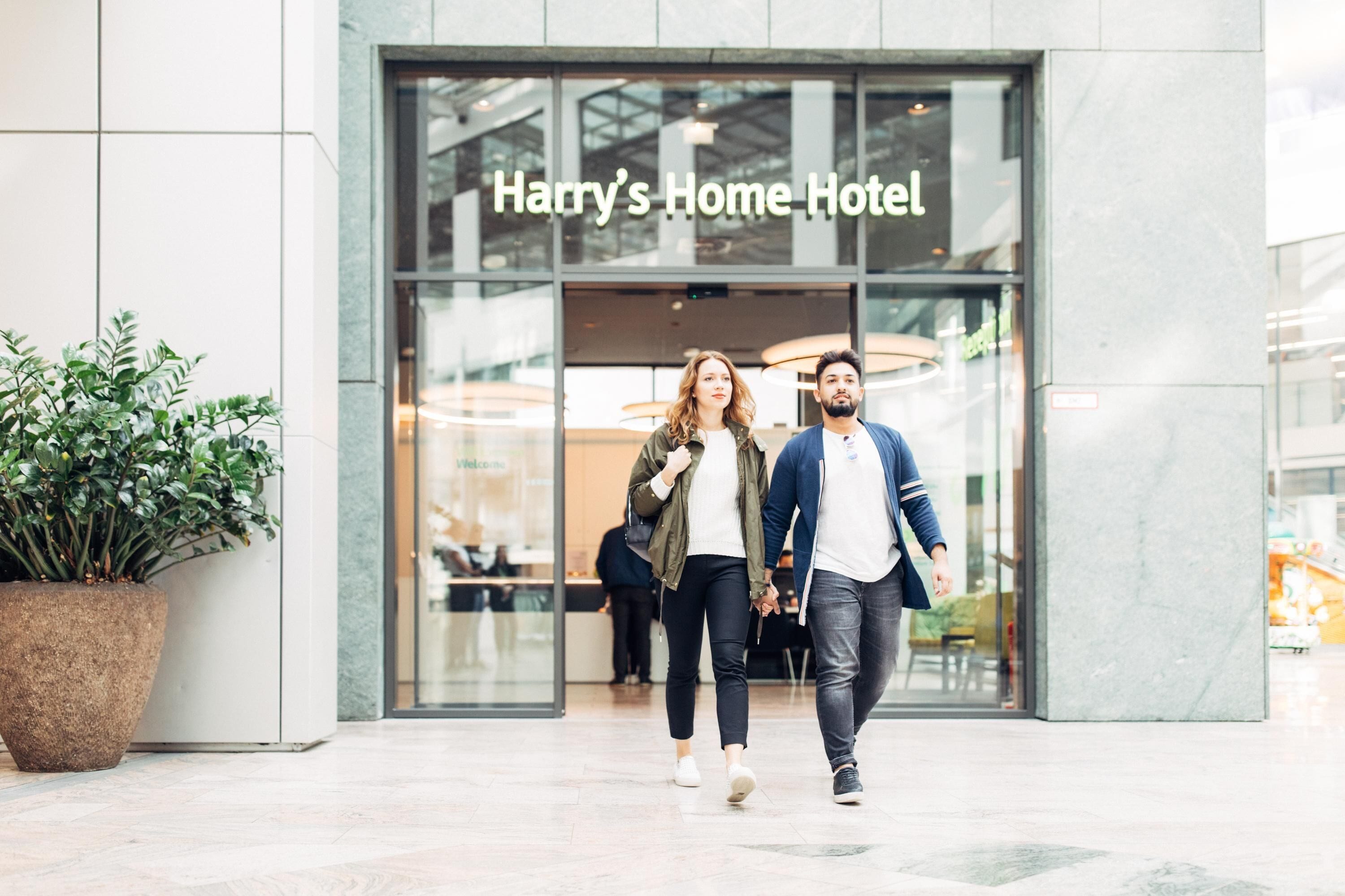 A couple walking in front of Harry's Home Hotel.