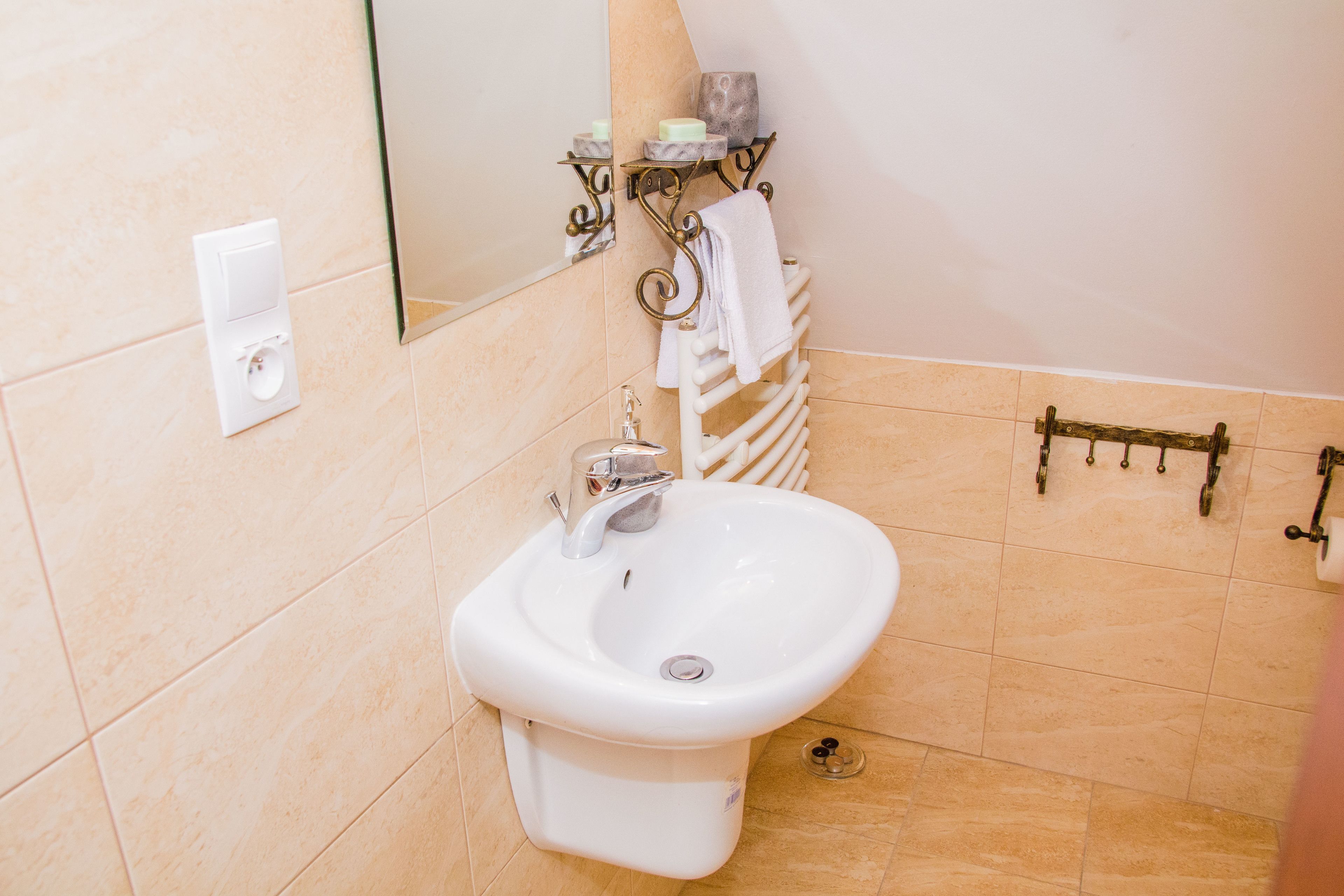 Un baño con bidé, perchero y espejo.