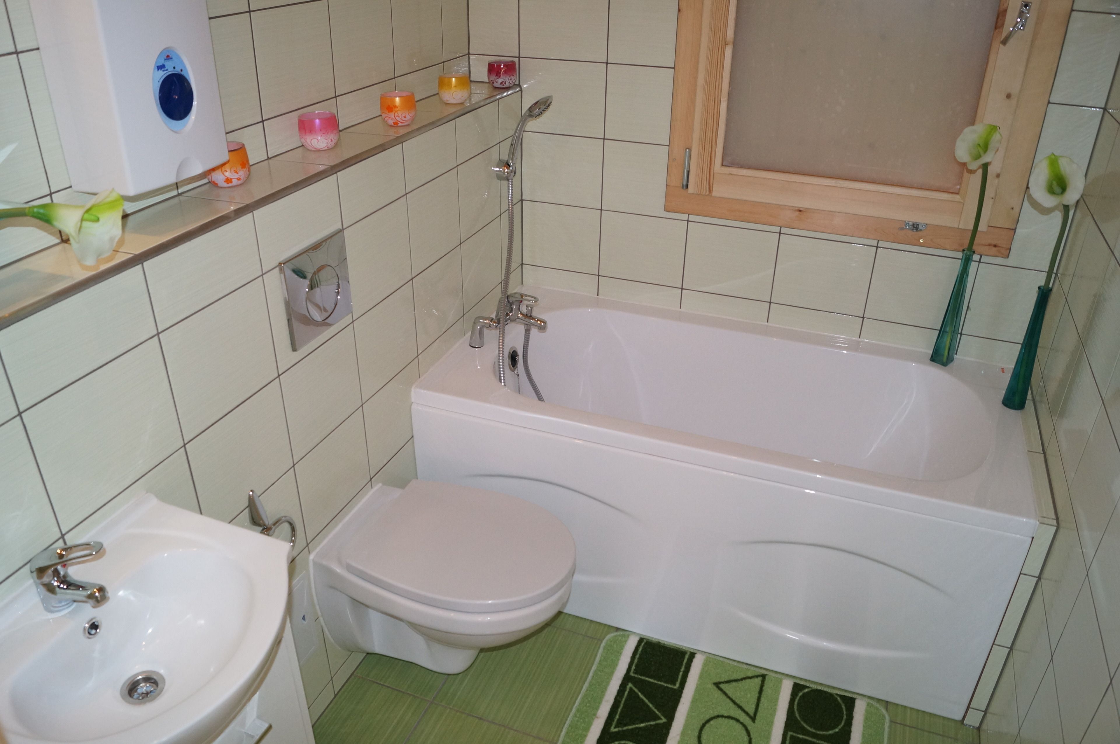Een badkamer met een bad, toilet, wastafel en planken met toiletartikelen.