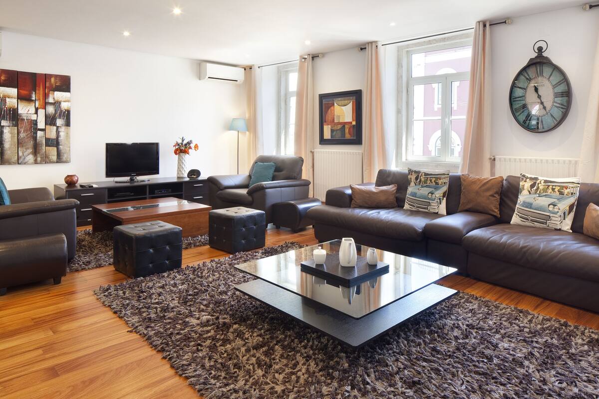 A modern living room with a sofa set, a coffee table, and a television.