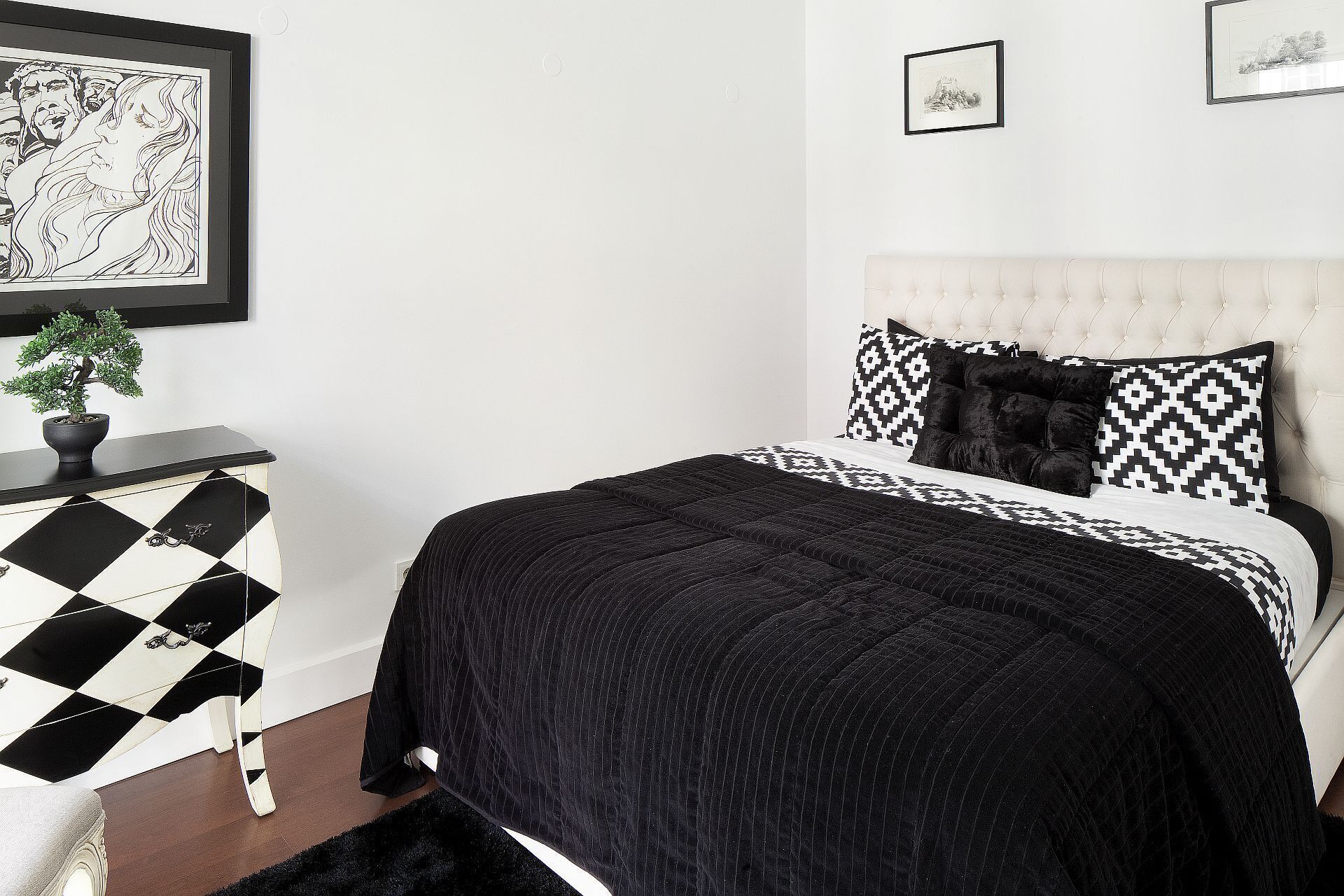 A bedroom with a bed, a dresser, and a potted plant.