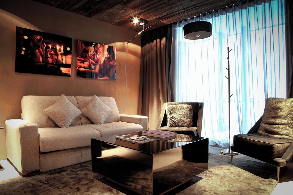 A modern living room with a sofa, armchair, and coffee table.