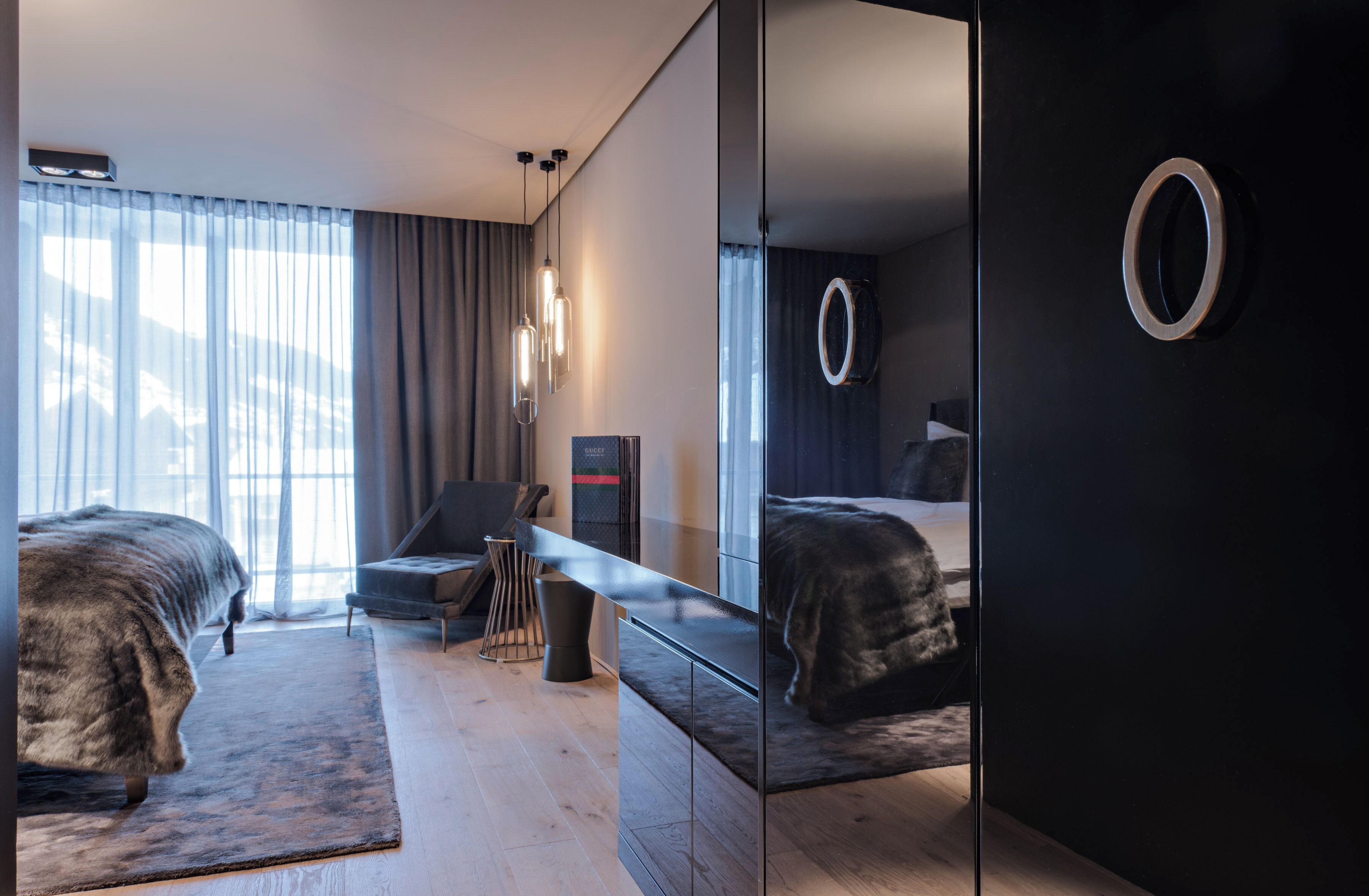 Una habitación de hotel moderna con una cama grande, un escritorio y un espejo.