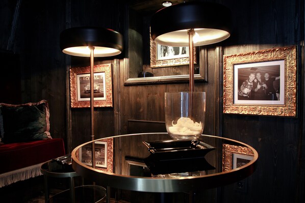 A round table with a glass centerpiece, surrounded by framed pictures on the wall. - Hotel Zhero - Ischgl/Kappl (Kappl)
