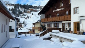 A snow-covered village with traditional wooden buildings, including a hotel named "Schrofenstein." - Haus Schrofenstein (Lech am Arlberg)
