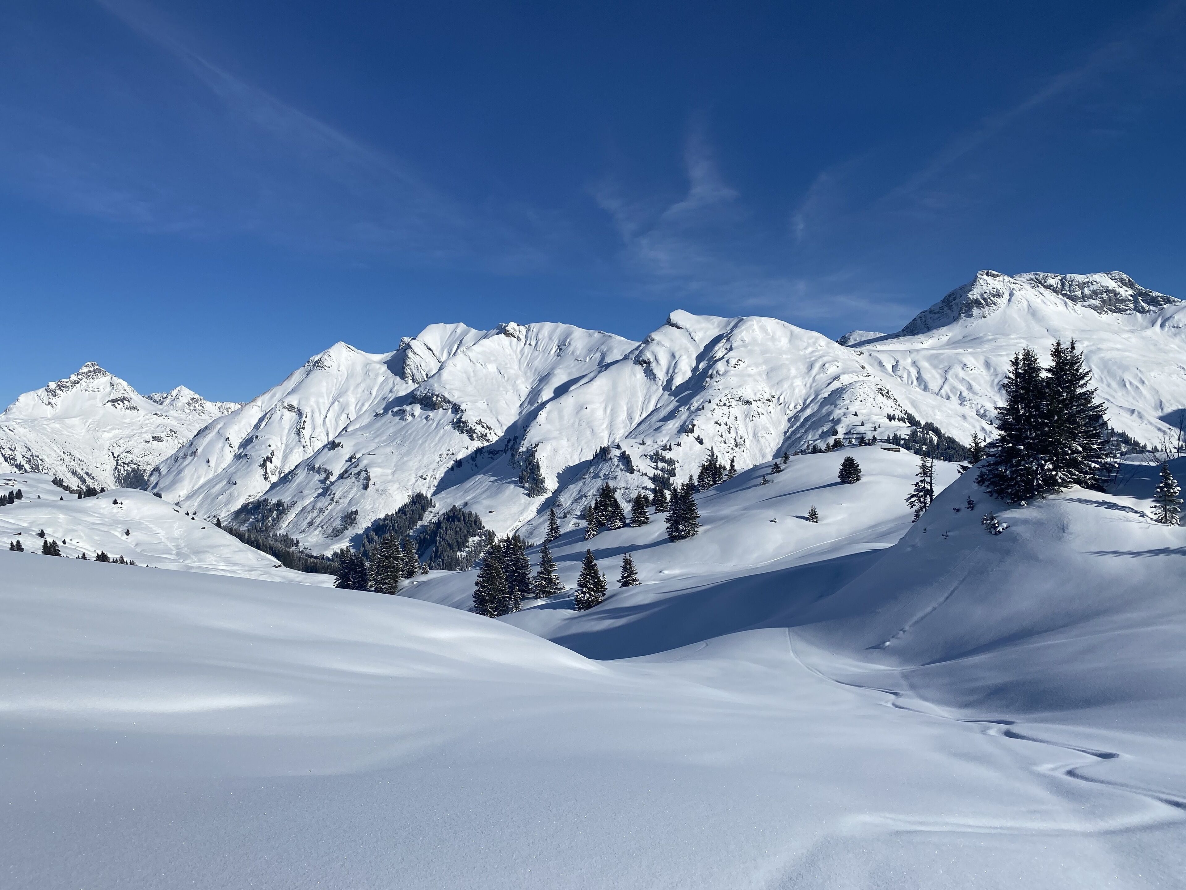 A snow-covered mountain landscape with clear skies.