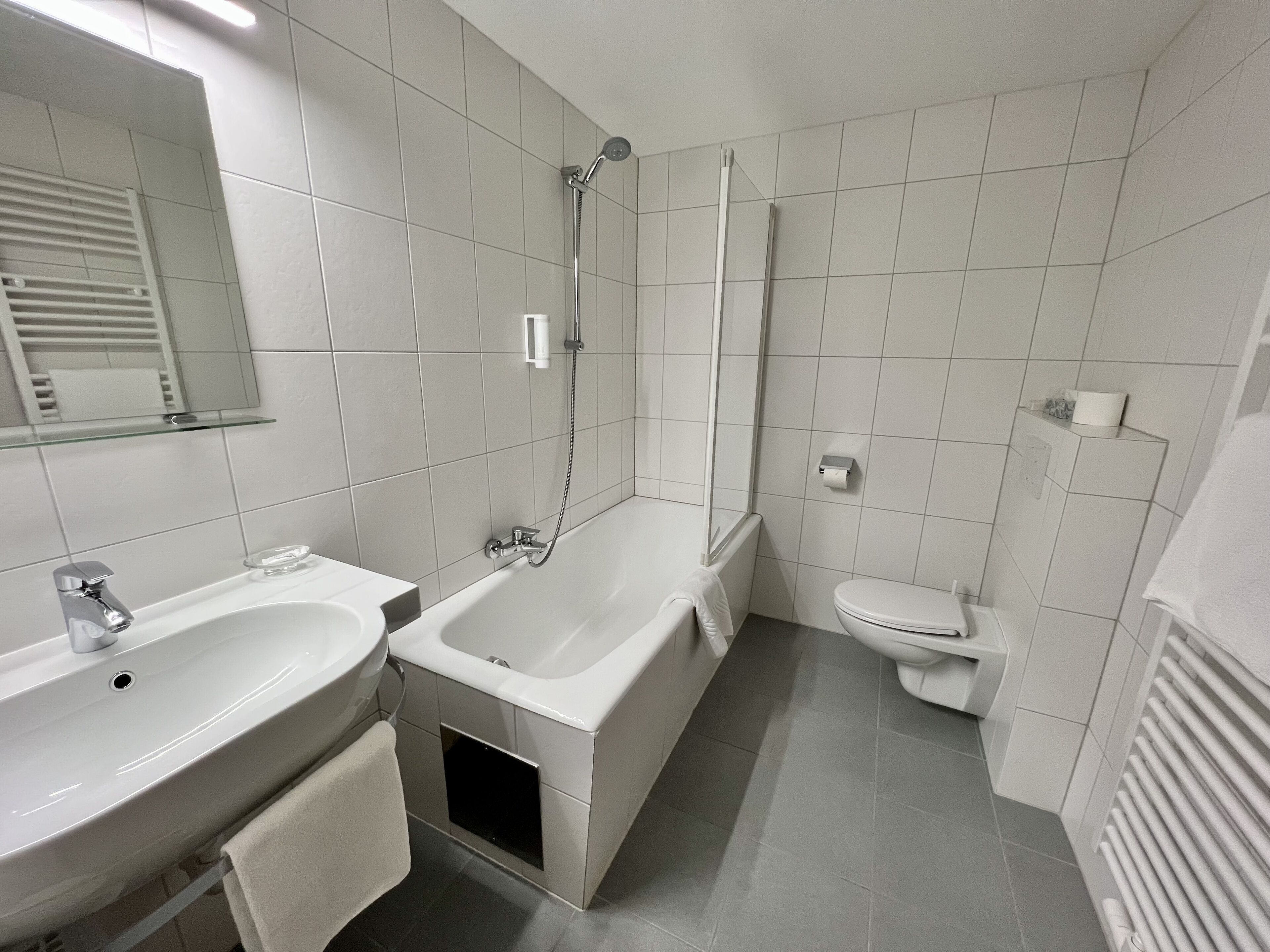 A modern bathroom with a sink, bathtub, and toilet.