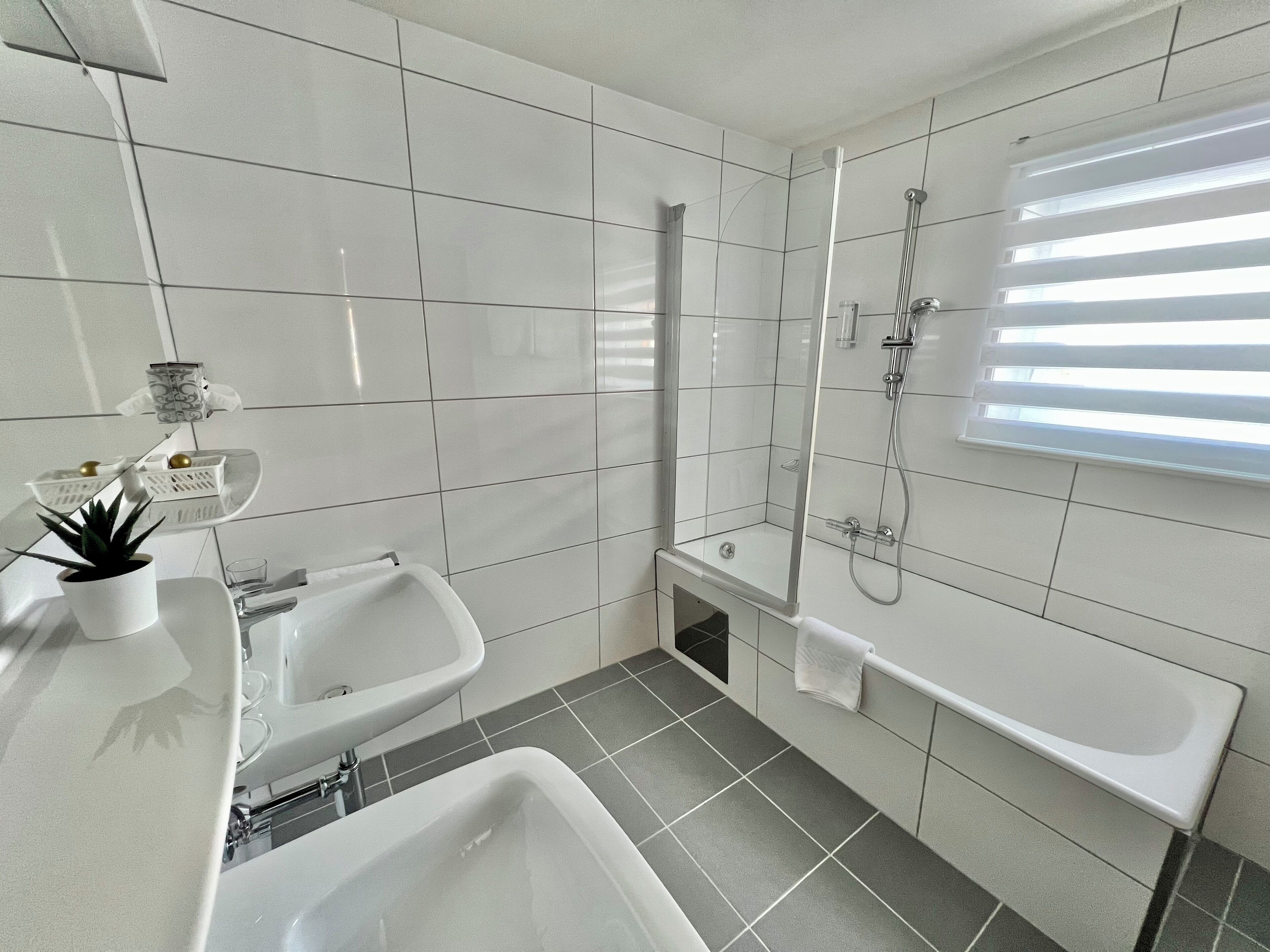 Un baño moderno con bañera, ducha y lavamanos.
