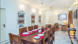 Un comedor con una larga mesa de madera dispuesta para una comida, rodeada de sillas.
