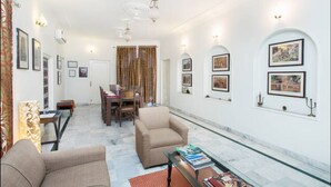 Un salón espacioso con una mesa de comedor, dos sillones y una mesa de centro de cristal.
