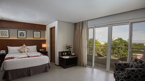 A hotel room with a bed, a desk, a chair, and a balcony with a view. - St. Mark Hotel (Cebu City)