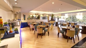 Un restaurant moderne avec un plancher en bois, des chaises bleues et beiges, et une variété de décorations de table.