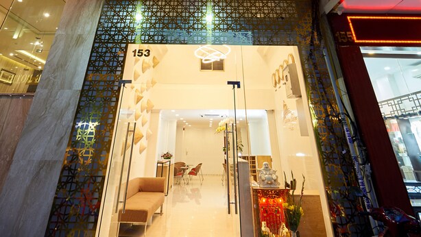 The entrance to Saigon Charm Boutique Hotel with a modern facade, a glass door entrance, and a decorative interior visible through the glass. - Saigon Charm Hotel (Ho Chi Minh City)