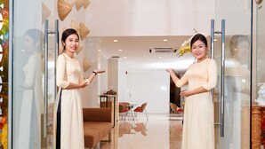 A modern interior with glass doors, a sofa, and a dining area. - Saigon Charm Hotel (Ho Chi Minh City)