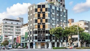 A hotel with a modern facade, multiple floors, and a prominent sign reading "Papa Whale Hotel." - The Icon Hotel (Kaohsiung)