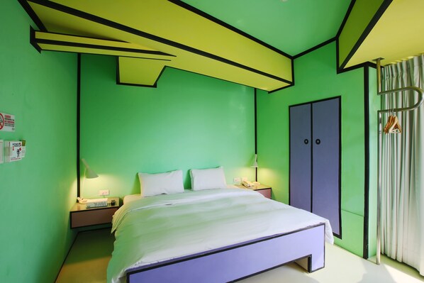Una habitación con cama, mesitas de noche, un armario y una cortina.