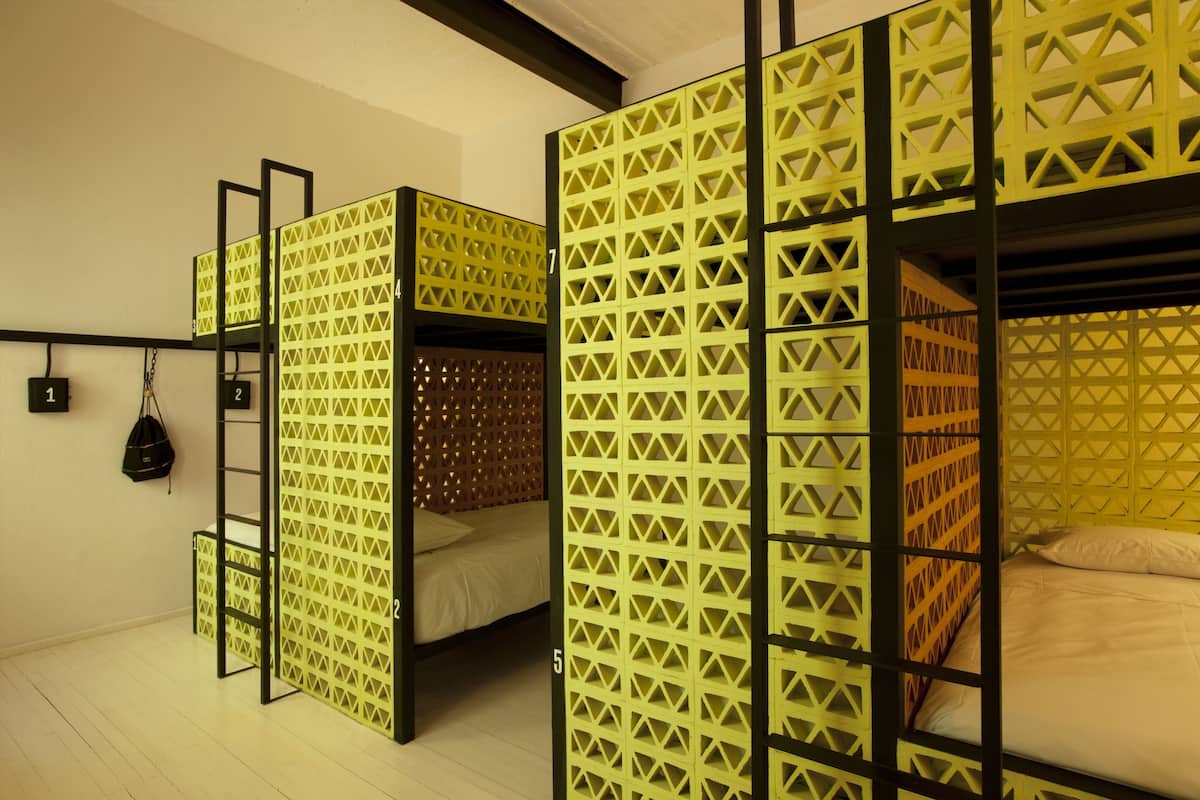 A room with bunk beds, each separated by a geometric-patterned partition.