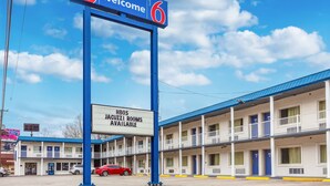 A motel with a blue sign reading "6 Welcome" and a sign below stating "HBOs Jacuzzi Rooms Available". - Motel 6 Huntington, WV (Huntington)