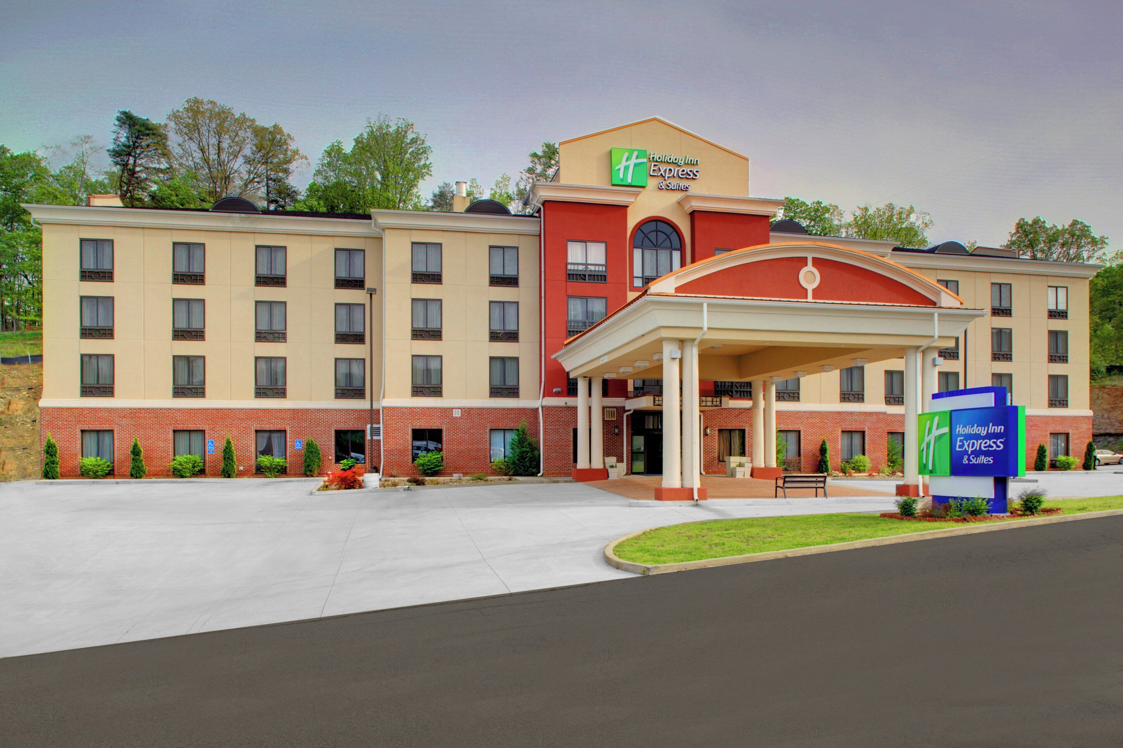 A Holiday Inn Express & Suites hotel with a covered entrance, multiple windows, and a brick facade.