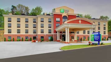 A Holiday Inn Express & Suites hotel with a covered entrance, multiple windows, and a brick facade.