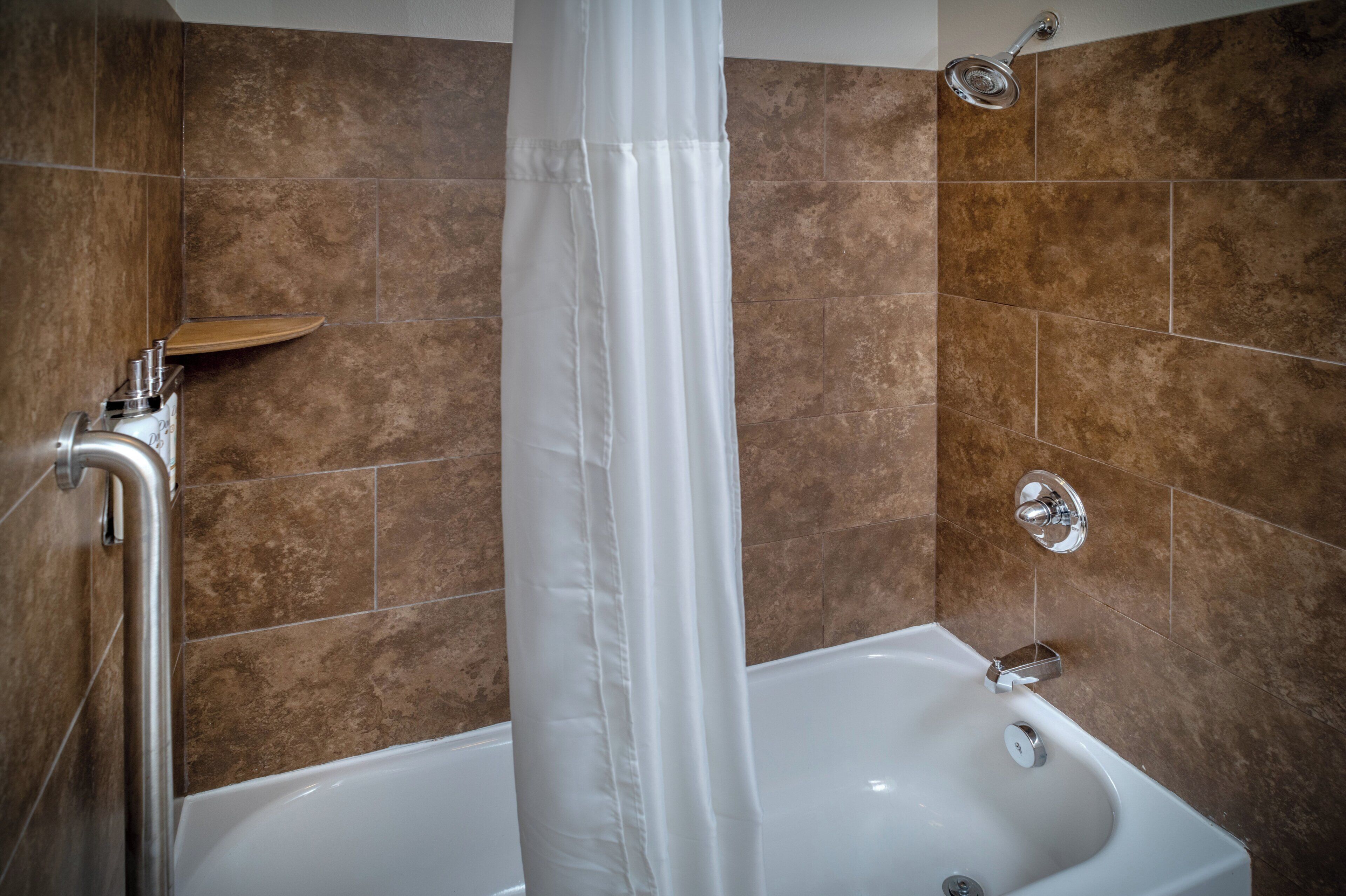 Un baño con bañera, ducha y cortina.