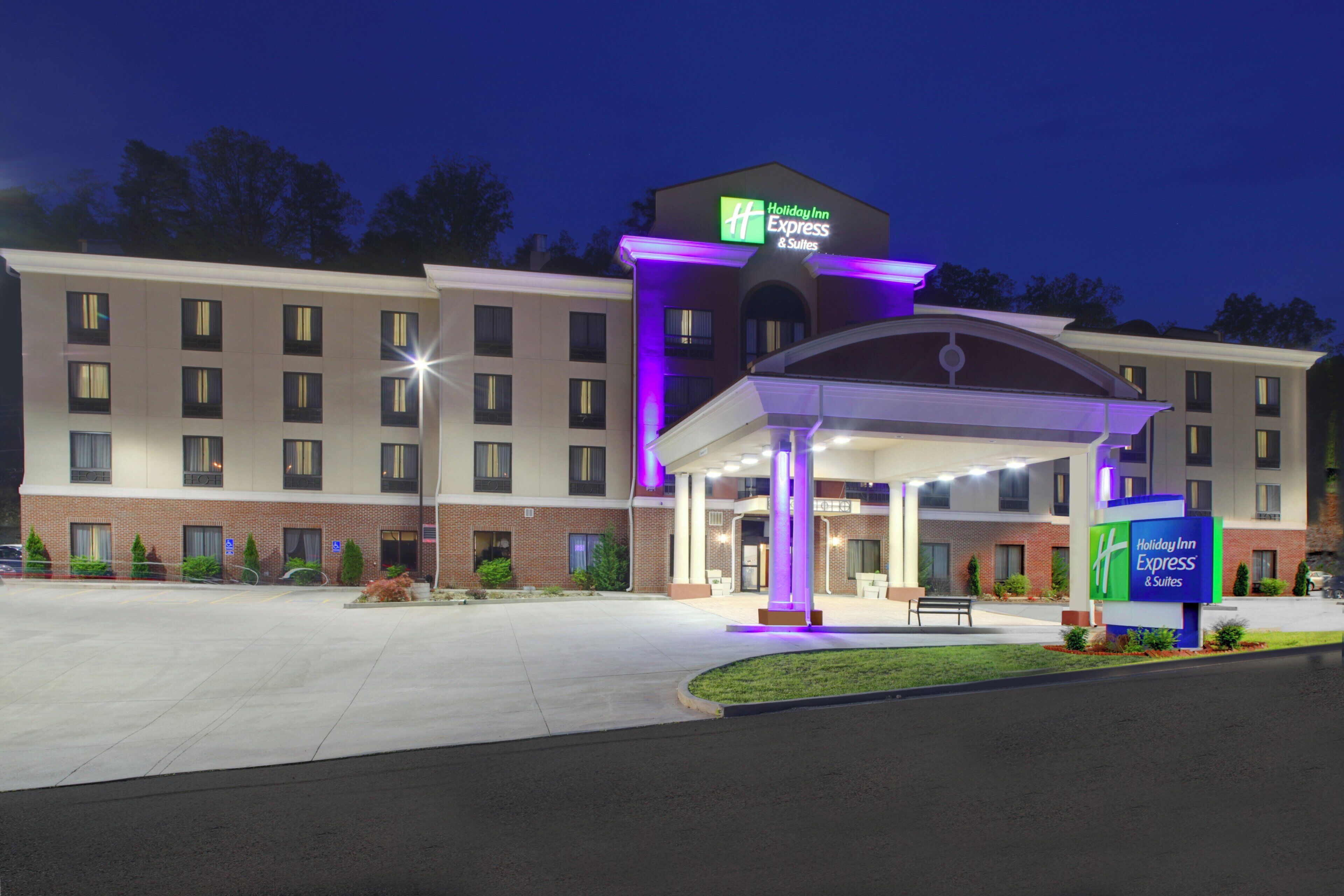Un hotel Holiday Inn Express & Suites con entrada cubierta y aparcamiento.