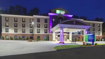 Un hotel Holiday Inn Express & Suites con entrada cubierta y aparcamiento.