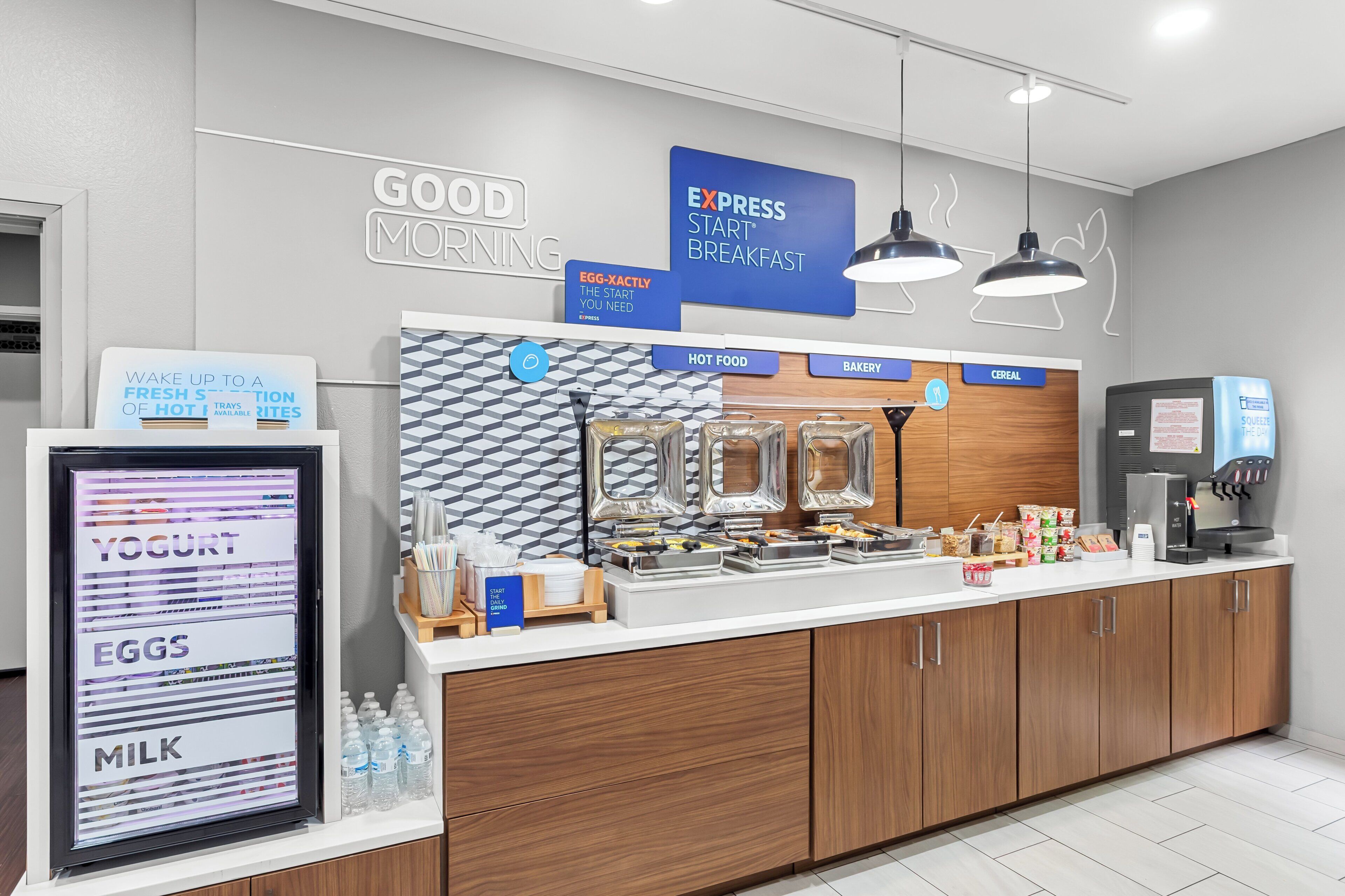 A breakfast bar with labeled sections for yogurt, eggs, milk, hot food, bakery, and cereal.