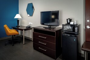 A hotel room with a desk, a television, a microwave, a coffee maker, and a chair. - Holiday Inn Express Hotel & Suites Cross Lanes by IHG (Cross Lanes)