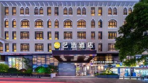 Un hotel con fachada moderna, varios ventanales y una entrada destacada con zona cubierta.