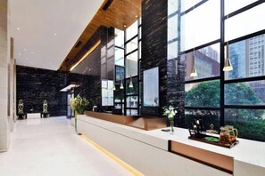 A modern reception area with a long counter, large windows, and a view of the cityscape. - Elong ME Hotel (Changsha Zhongmao City) (Changsha)