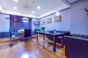 Una habitación de hotel con comedor, sofá y mesa.