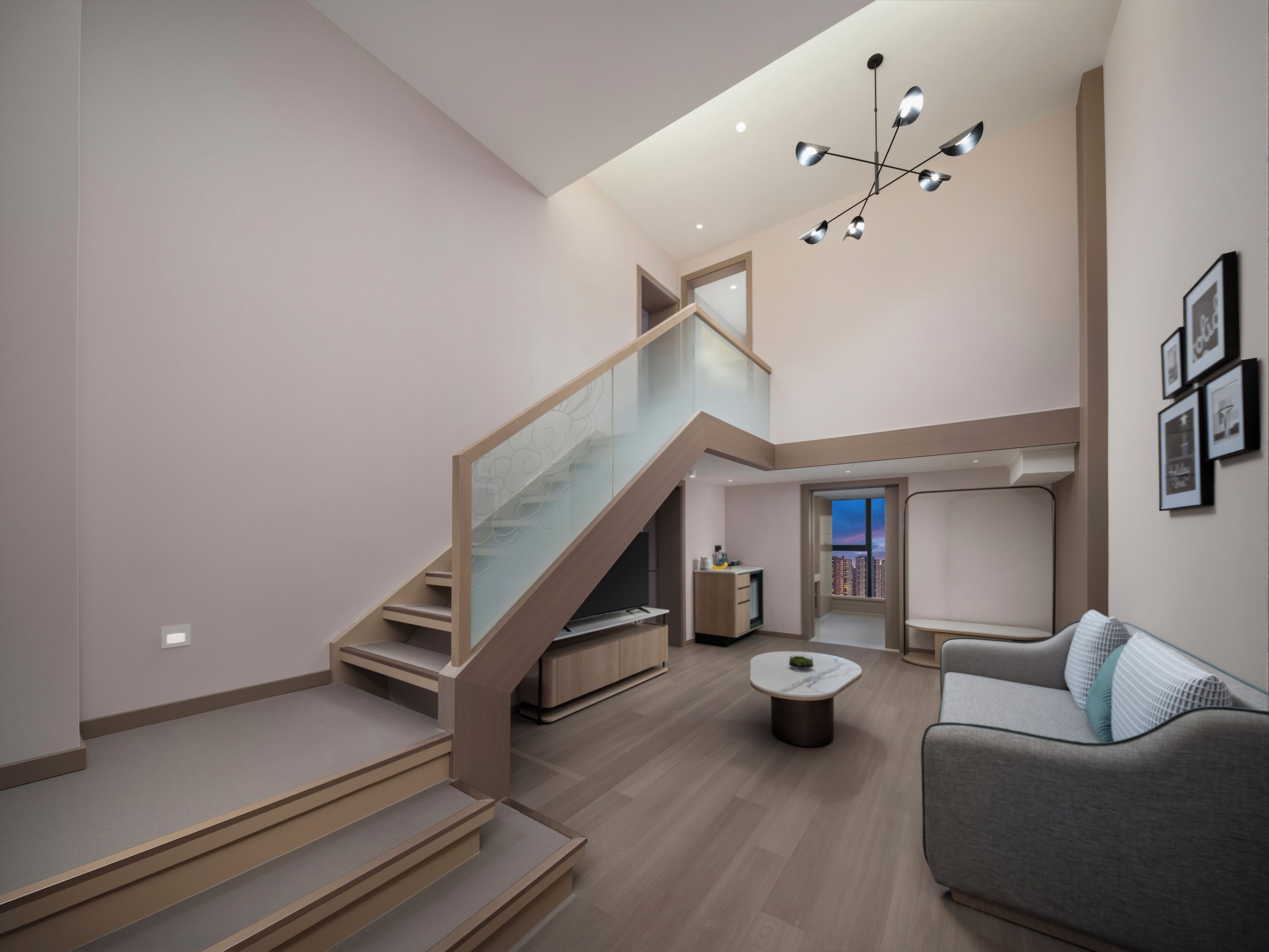 A modern interior with a staircase, a living area, and a view of the cityscape.
