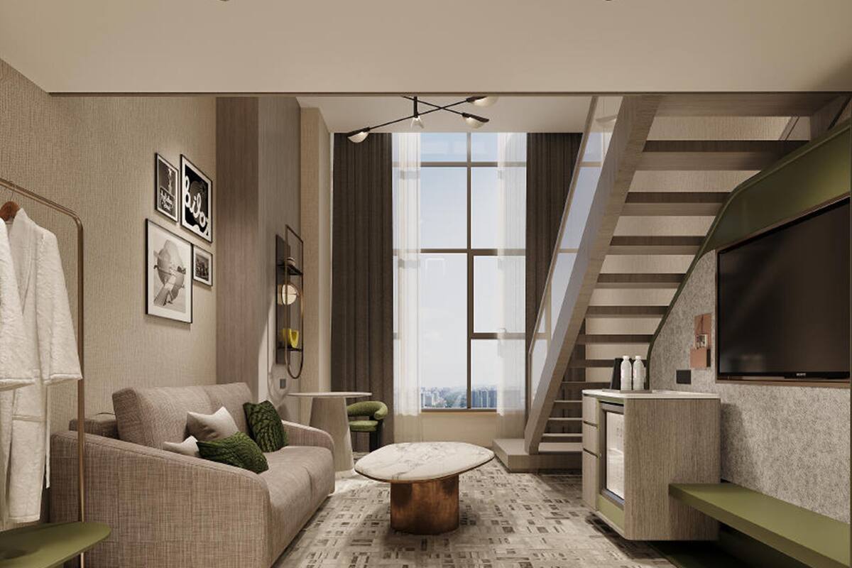 A modern living room with a sofa, coffee table, and a staircase.