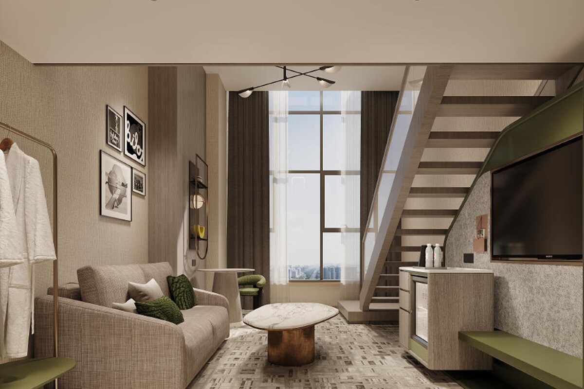 A modern living room with a sofa, coffee table, and a staircase.
